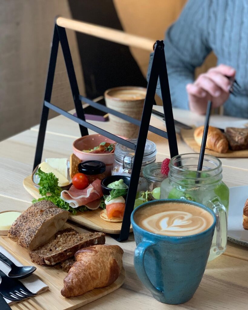 Brunchbord med kaffe, croissant og pålæg.